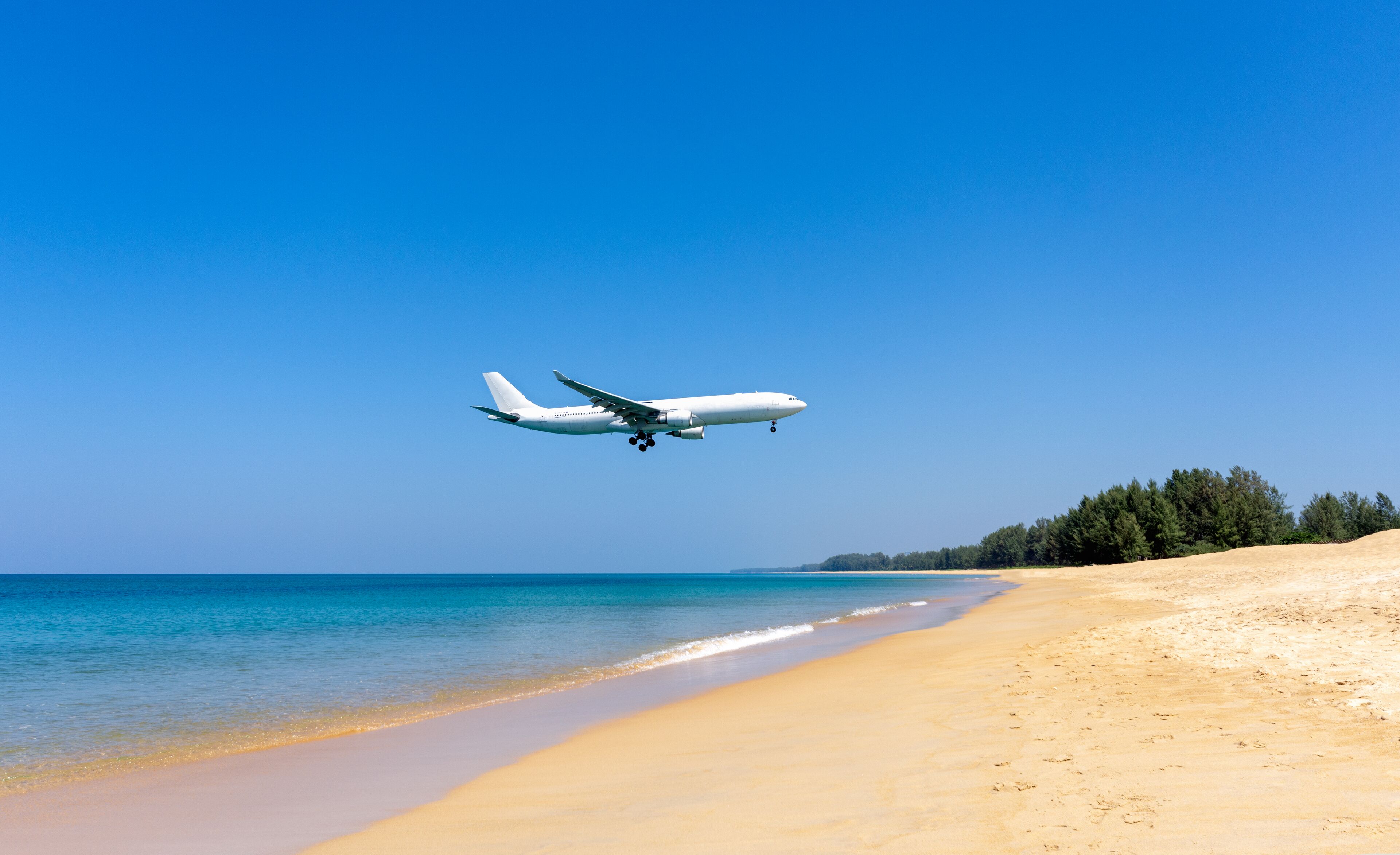 Pristine and peaceful Mai Khao Beach in Phuket with turquoise Andaman Sea and casuarina trees