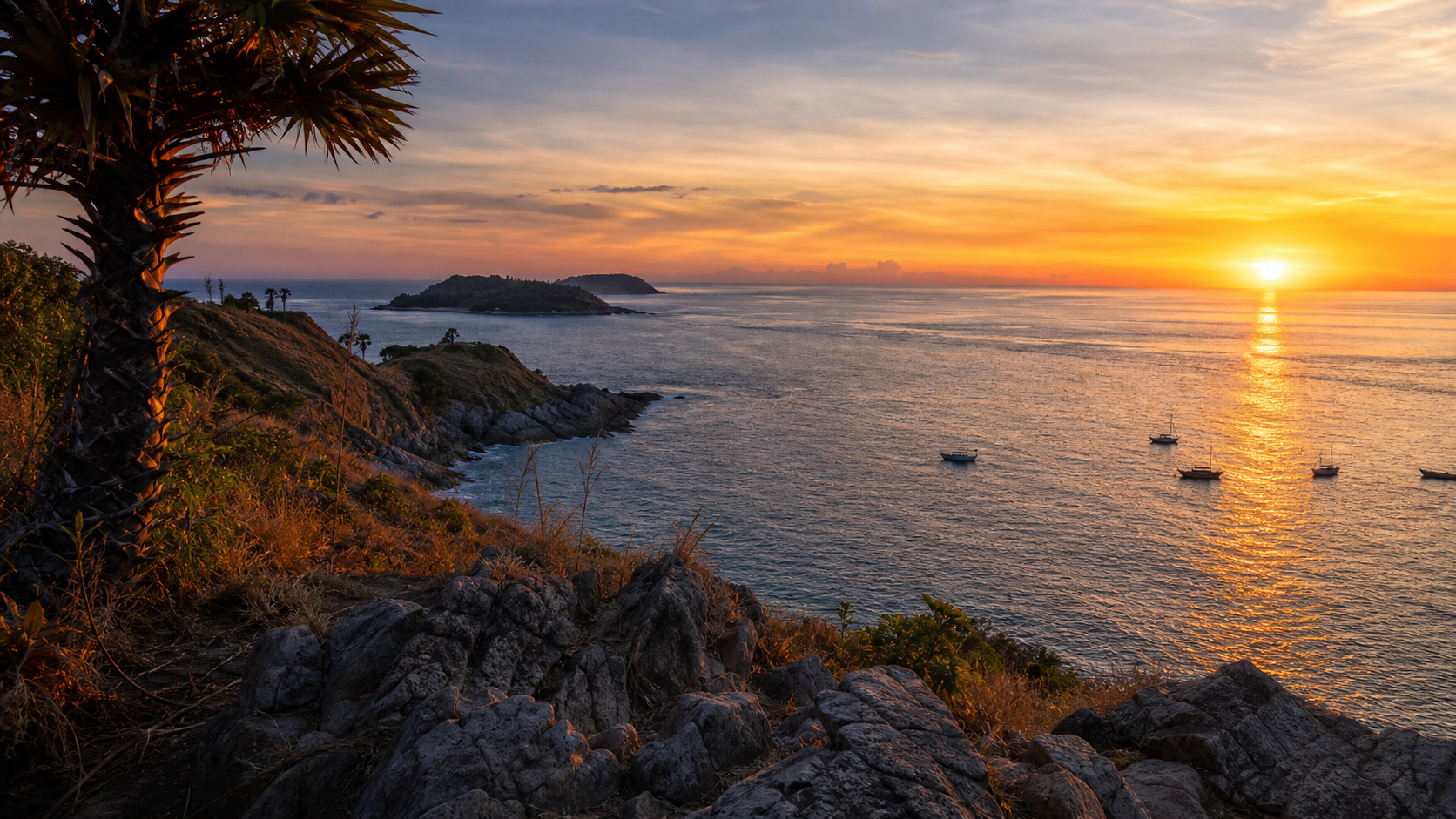 Sunset over the rocky southern headland at Promthep Cape